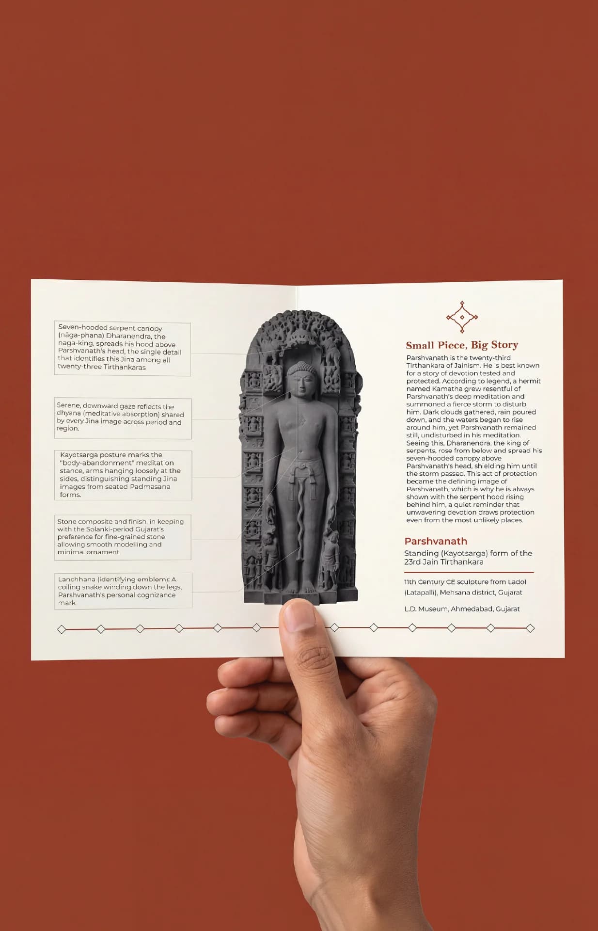 A hand holds an informational brochure featuring the Parshvanath Sculpture, a stone composite replica with detailed historical annotations.