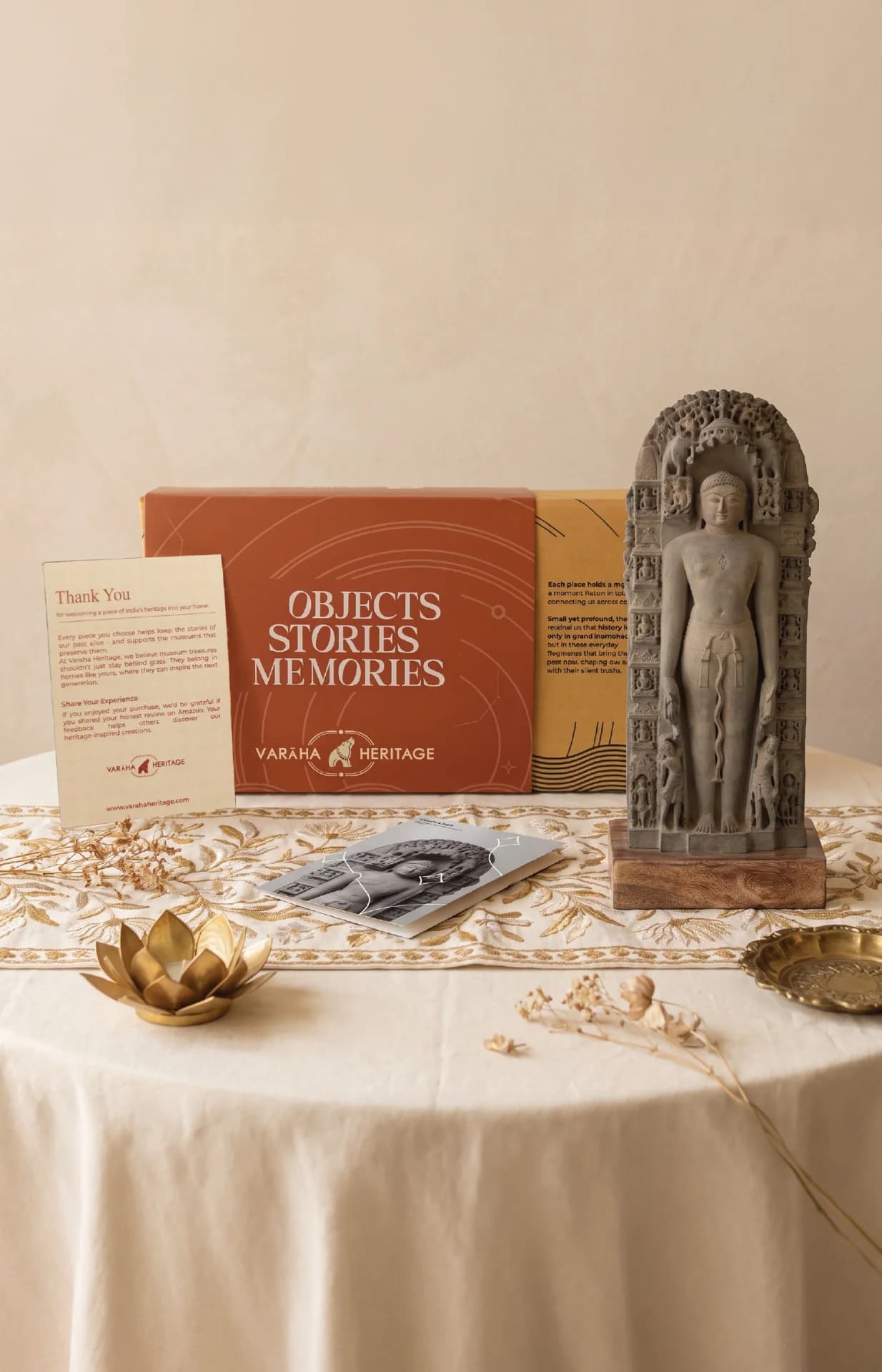 The Parshvanath Sculpture displayed on a table alongside its heritage packaging, thank you card, and informational booklet.