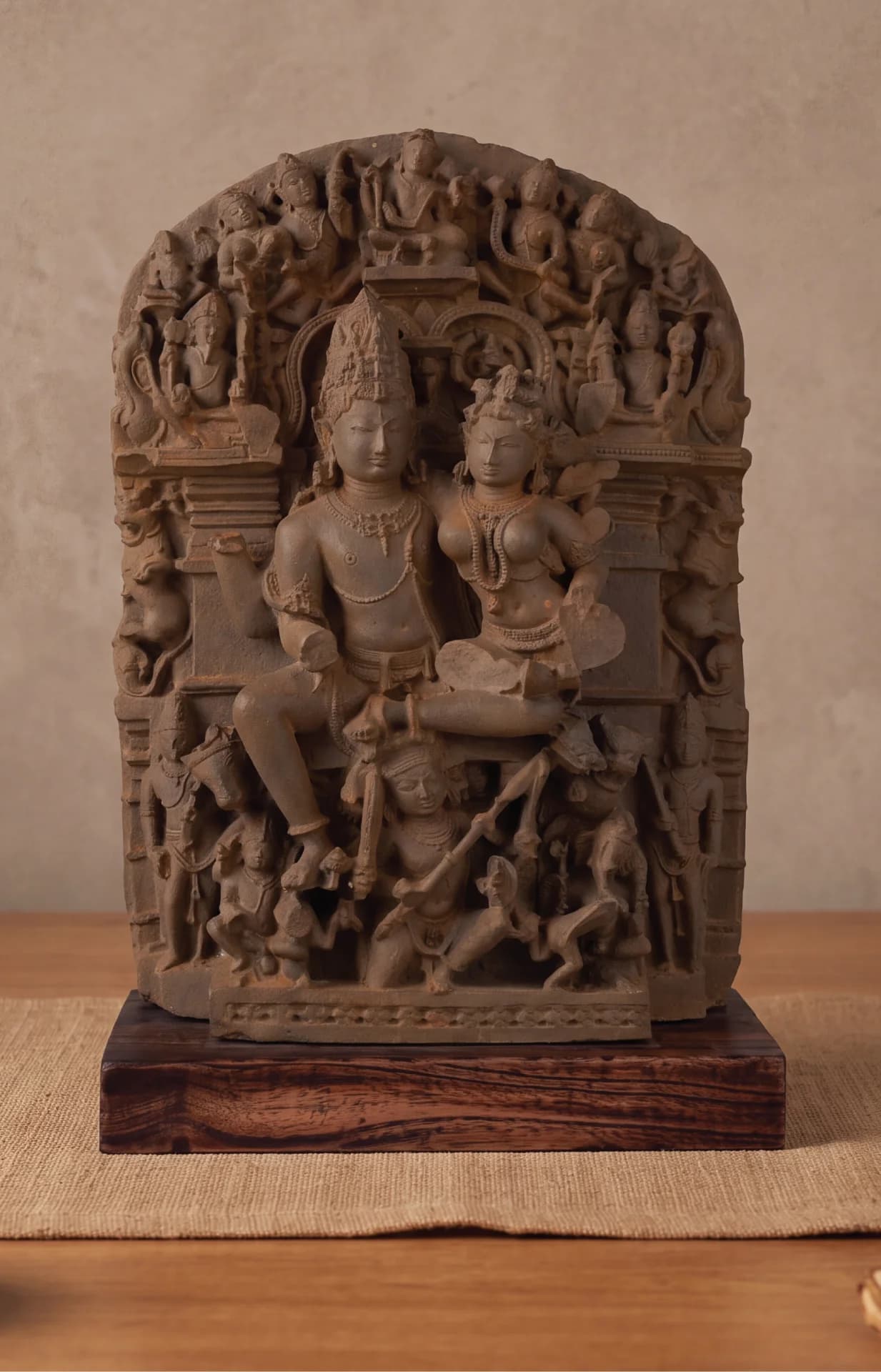 A front-facing view of the Ravananugraha Sculpture, a stone composite museum replica showing intricate carvings of Shiva and Parvati.