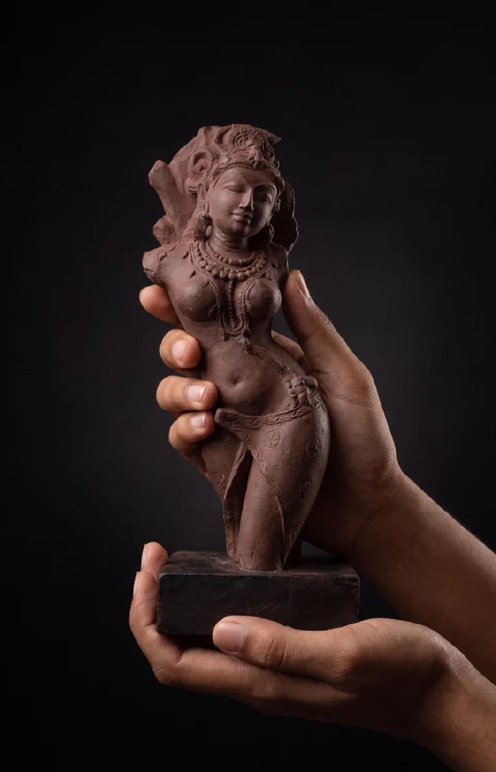 A pair of hands holds a stone composite Salabhanjika Sculpture, showcasing the intricate details of this museum replica figure.