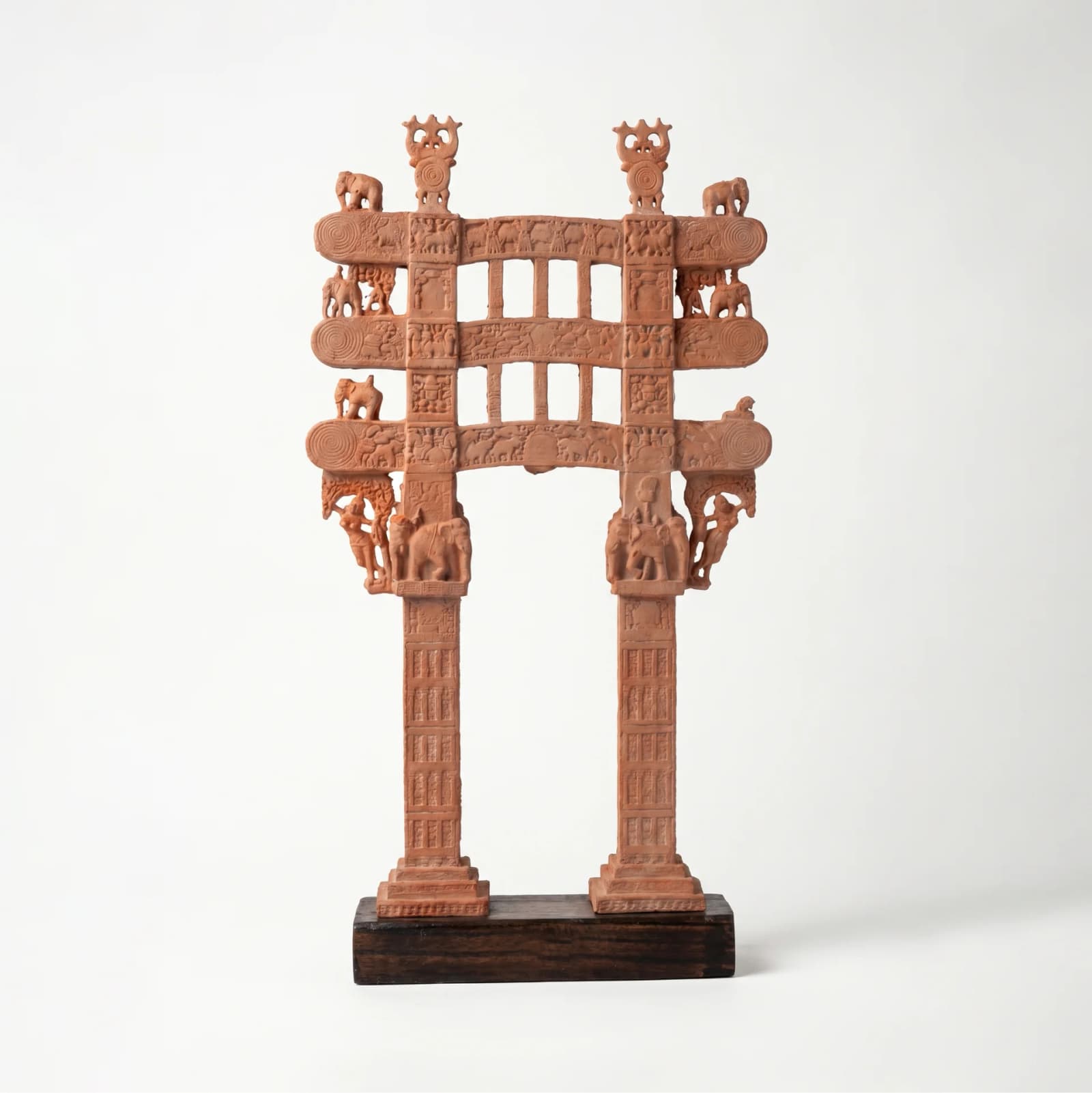 A full-front view of the Sanchi Torana Gateway Miniature, a detailed stone composite replica featuring intricate carvings on a wooden base.