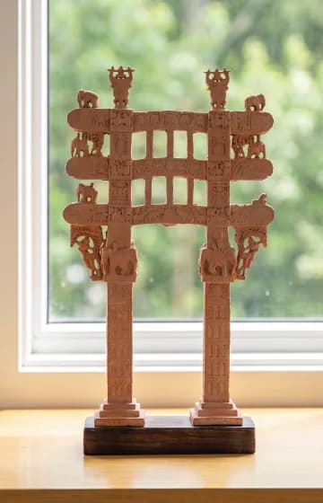A front view of the Sanchi Torana Gateway Miniature, a terracotta-style replica featuring intricate carvings of elephants and figures.