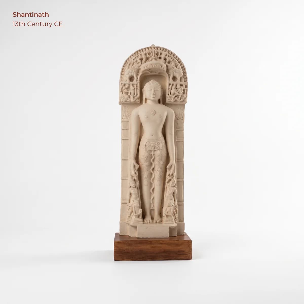 A full front view of the Shantinath Sculpture museum replica, featuring intricate marble-style carving within a decorative arched niche.