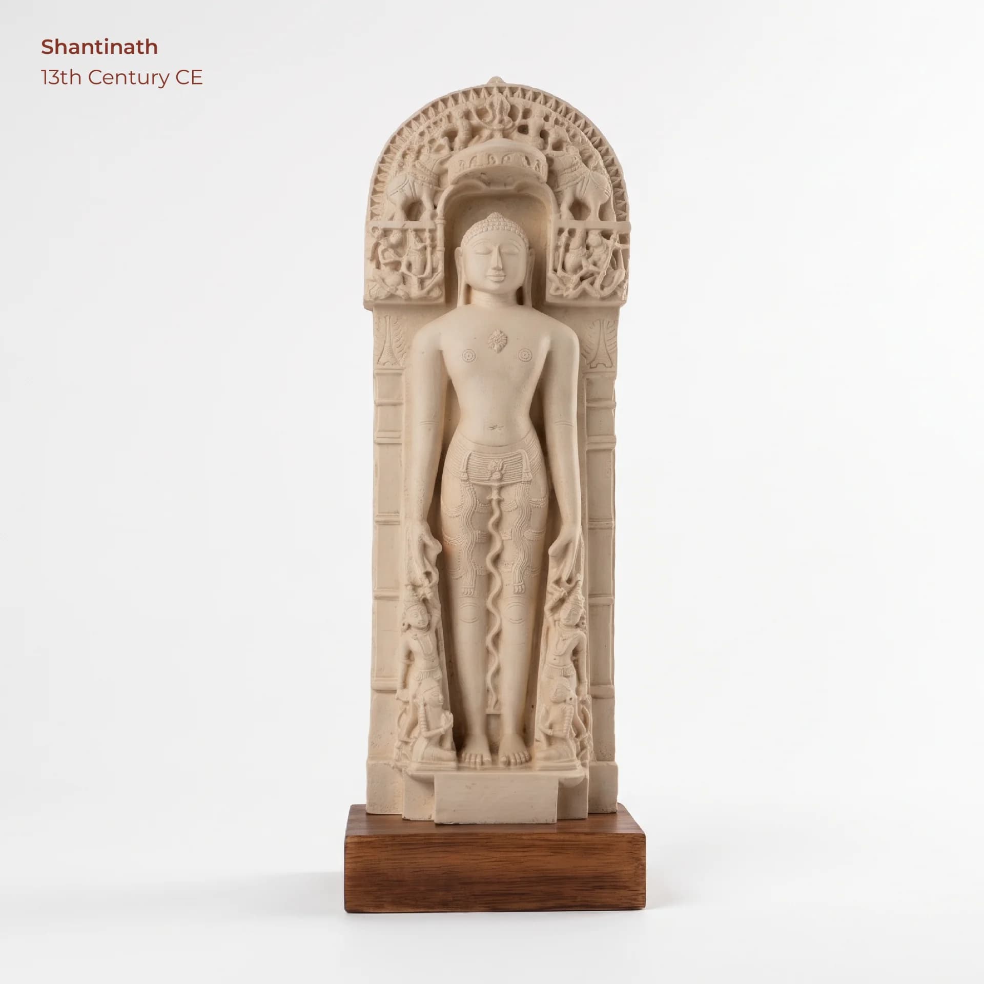 A full-length front view of the Shantinath Sculpture, a marble-style museum replica featuring intricate carvings and a wooden base.