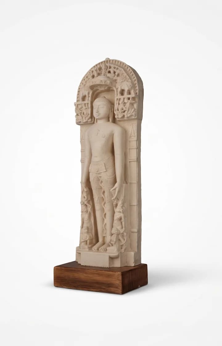 A three-quarter view of the Shantinath Sculpture, a marble-style museum replica featuring intricate carvings and a wooden base.