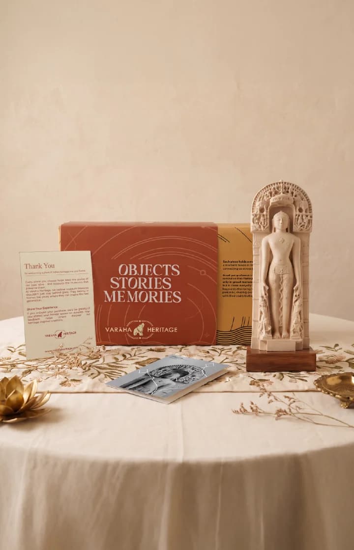 The Shantinath Sculpture museum replica displayed on a table alongside its premium branded packaging and a thank you card.