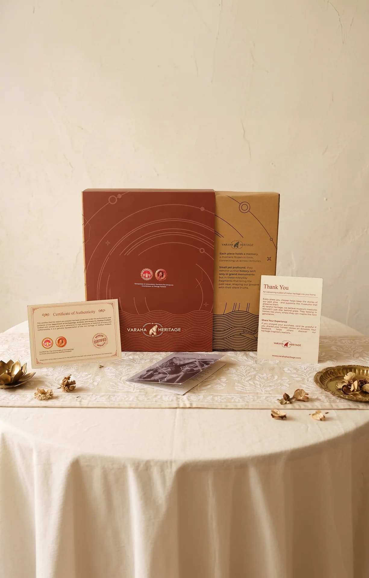 The Tripurantaka Shiva Sculpture packaging set includes a decorative box, certificate of authenticity, and thank you note on table.