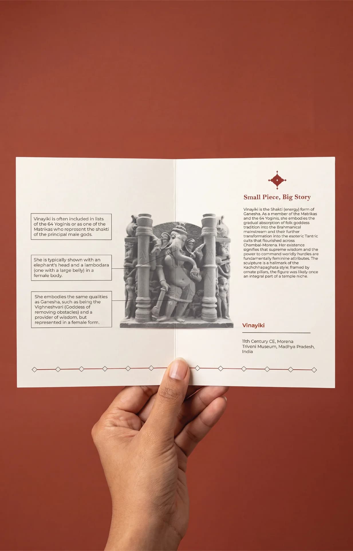 A hand holds an open brochure featuring the Vinayaki Sculpture, showcasing detailed Kachchapaghata stone-style iconography and educational text about the artifact.